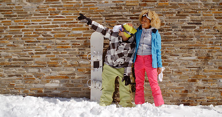 Image showing Snowboarder with happy friend pointing upwards