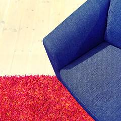 Image showing Blue textile armchair on red carpet