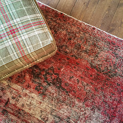 Image showing Checked textile hassock and vintage style carpet