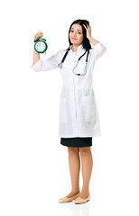 Image showing Young female doctor with clock