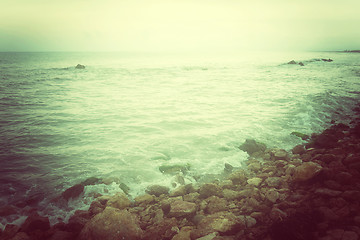 Image showing Rocky coast and stormy sea in green glow