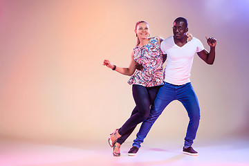 Image showing Young couple dances social Caribbean Salsa, studio shot 