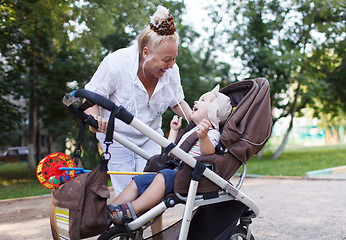 Image showing Granny playing with her grandson in pram