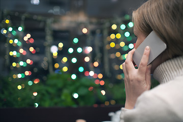 Image showing Woman in cafe talking on the phone