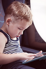Image showing Little child using touch pad while traveling by bus