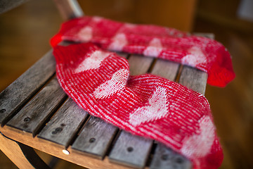 Image showing Red woollen socks on wooden chair