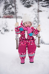 Image showing little girl at snowy winter day swing in park