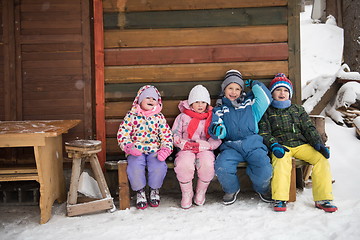 Image showing little children group sitting  together  in front of wooden cabi