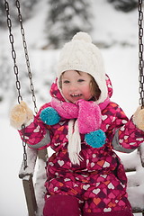 Image showing little girl at snowy winter day swing in park