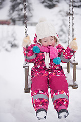 Image showing little girl at snowy winter day swing in park