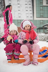 Image showing portrait of two little girls sitting together on sledges