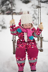 Image showing little girl at snowy winter day swing in park