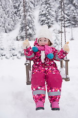 Image showing little girl at snowy winter day swing in park