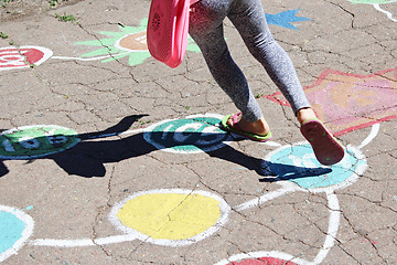 Image showing girl runs on the childish drawings on the asphalt 