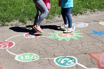 Image showing girls run on the childish drawings on the asphalt 