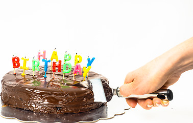 Image showing Female person cutting a homemade sacher chocolate cake with birt