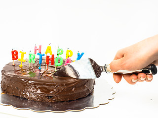 Image showing Female person cutting a homemade sacher chocolate cake with birt