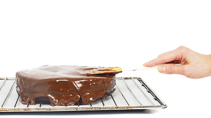 Image showing Pastry chef making final touches to a sacher chocolate cake with