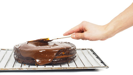 Image showing Pastry chef making final touches to a sacher chocolate cake with