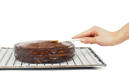 Image showing Pastry chef making final touches to a sacher chocolate cake with