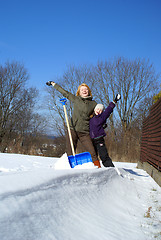 Image showing mother and her daughter throw up snow on a winter background