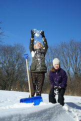 Image showing mother and daughter shoveling and have fan outside