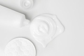 Image showing splash of white cream, tube and cosmetic cotton disk