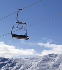 Image showing Chair lift and snowy mountains at nice day