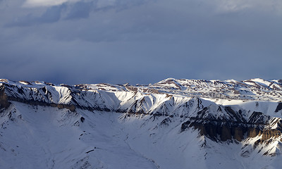 Image showing Sunlight winter mountains and dark clouds at evening