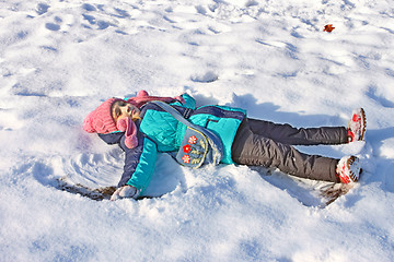 Image showing Little girl lying on a snow