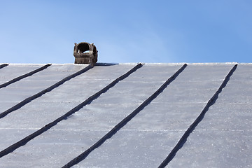 Image showing Chimney on an old tinny roof