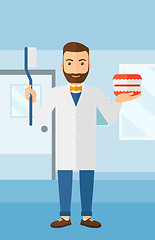 Image showing Dentist with dental jaw model and toothbrush.