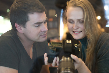 Image showing Young people looking through the photos on camera