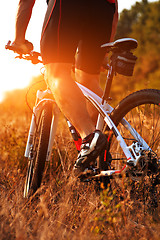 Image showing Close up rear view of man spining bike pedals