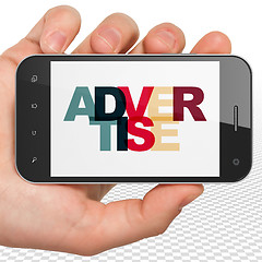 Image showing Marketing concept: Hand Holding Smartphone with Advertise on  display