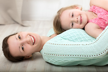 Image showing Smiling mother and daughter on the floor