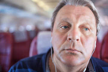 Image showing Man listening to music in the airplane