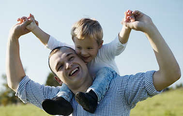 Image showing Dad giving his young son a piggy back ride