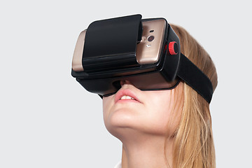 Image showing Young woman entertaining with VR-Helmet