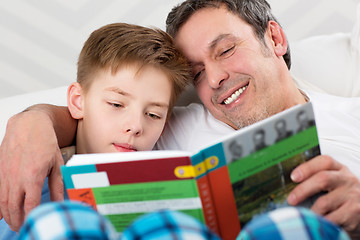 Image showing Son and father reading book together