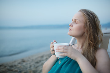 Image showing Woman with closed eyes enjoying a cup of tea