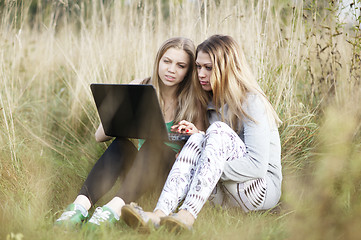 Image showing Female friends with laptop outdoor