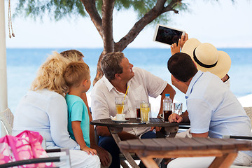 Image showing Family selfie with tablet PC in outdoor cafe on resort