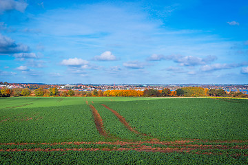 Image showing Tracks on a field near a city