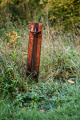 Image showing Rusty metal pole on a field