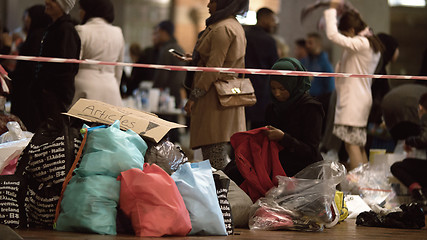 Image showing Female Aid Worker Distributing Clothes at Charity Collecting Point in Copenhagen Railroad Station