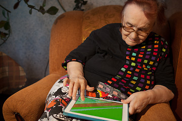 Image showing Senior woman surfing the internet on a tablet