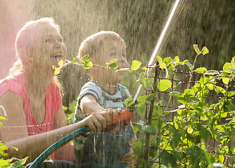 Image showing Mother and her young son playing with water