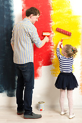 Image showing Father and daughter painting wall