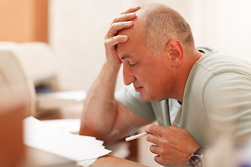 Image showing Mature businessman smoking in the office